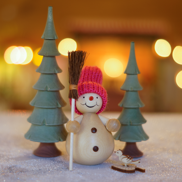 Schneemann mit Besen im Wald